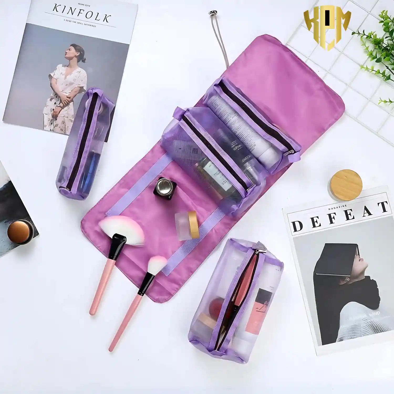 KPM WORLD™ purple hanging cosmetic organizer displayed flat with detachable mesh pouches organizing skincare, makeup, brushes, and travel essentials.